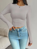 Langärmliges Damen-Kurztop mit Taillenbetonung und schmal geschnittenem Rundhalsausschnitt für den Alltag im Frühling und Herbst im Basic-Stil.